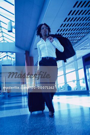 Businesswoman Walking in Terminal Pulling Luggage