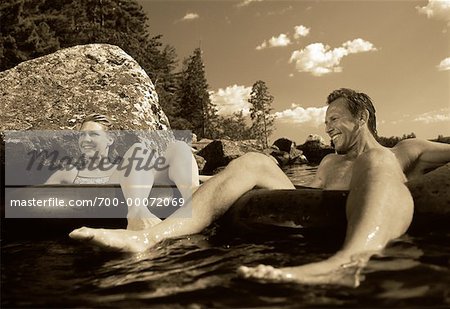 Couple Wearing Swimwear in Inner Tubes on Lake Belgrade Lakes, Maine, USA