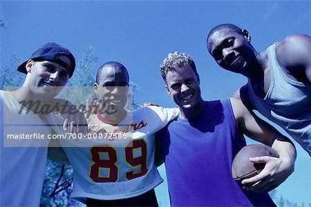 Group Portrait of Men Huddled With Football Outdoors