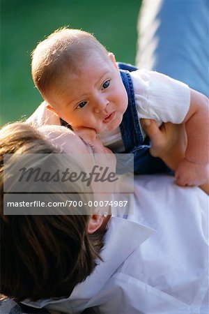 Mother Lying on Ground, Holding Baby Outdoors