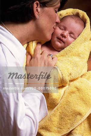 Mother Kissing Baby Wrapped in Towel