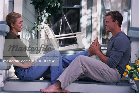 Couple Sitting on Porch Steps Man Massaging Woman's Feet