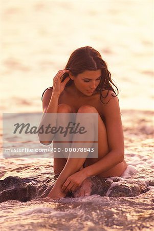 Nude Woman Sitting in Surf - Stock Photo - Masterfile