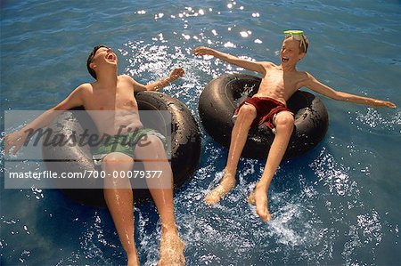 Two Boys in Swimwear on Inner Tubes in Water - Stock Photo - Masterfile -  Rights-Managed, Artist: Roy Ooms, Code: 700-00079377