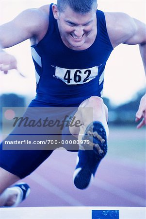 Male Athlete Jumping Hurdles