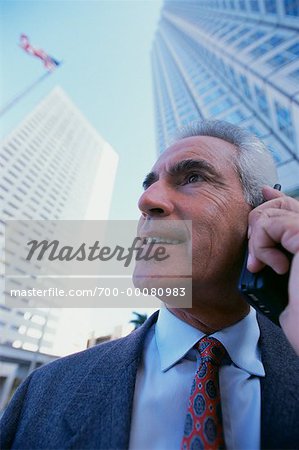 Mature Businessman Using Cell Phone Outdoors