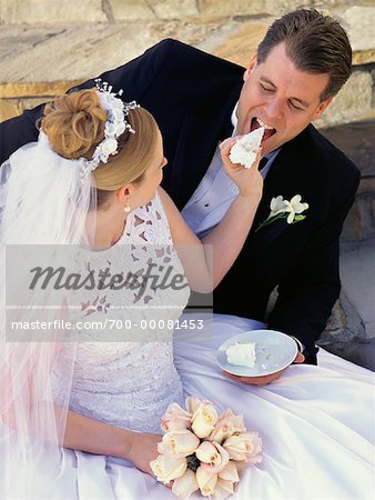 Bride Feeding Groom Slice of Wedding Cake