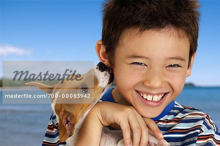 Portrait of Boy with Dog Licking Ear