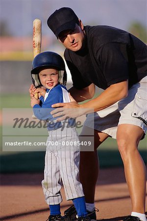 Coach Helping Boy in Baseball Uniform at Batting Practice