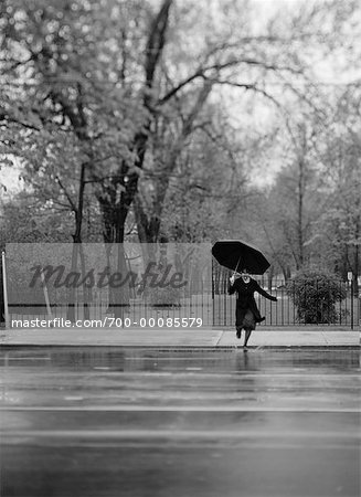 Woman Crossing Street with Umbrella in Rain