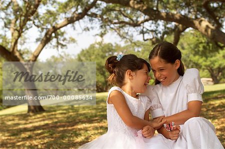 Two Girls Wearing Dresses Playing with Toy Butterfly and Laughing