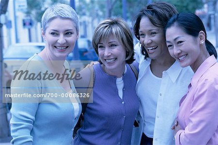 Four Women Standing Outdoors Smiling