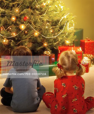 Boy and Girl by Christmas Tree