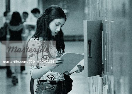 Teenage Girl Reading at Locker
