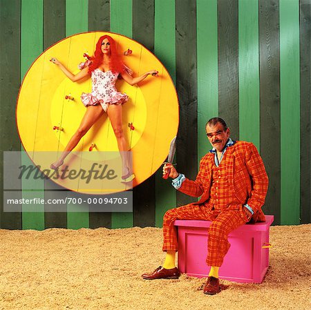 Woman on Spinning Wheel with Man Holding Knife