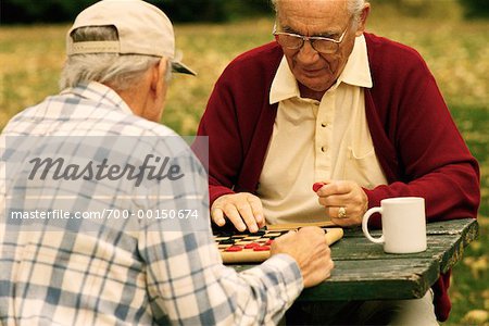 Two Mature Men Playing Checkers Outdoors