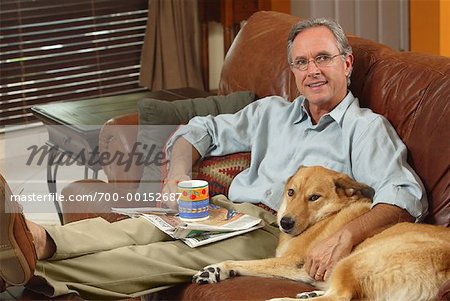 Man Sitting on Sofa with Dog