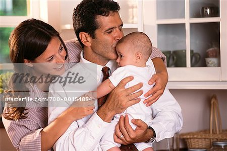 Father Kisses Baby While Mother Watches