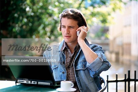Man on Cell Phone With Laptop