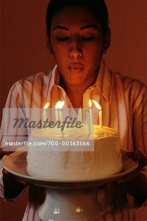 Woman Blowing Out Candles