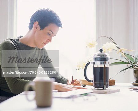 Woman Writing at Kitchen Table