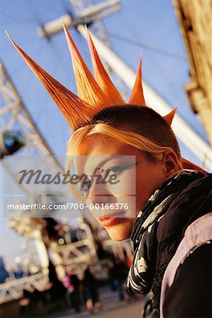 Young Woman with Mohawk Hairstyle Standing Next to Ferris Wheel