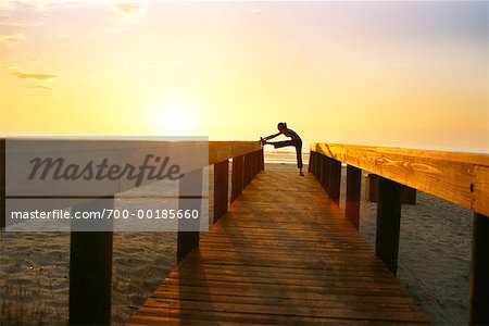 Woman Stretching on Beach Boardwalk