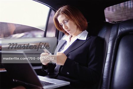 Woman Using Laptop and Phone In Limo