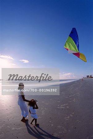 Mother and Daughter Flying Kite on Beach