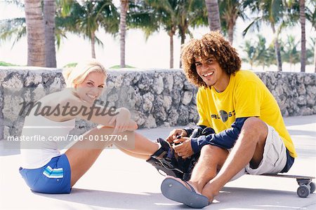 Young Man and Young Woman with In-Line Skates and Skateboard