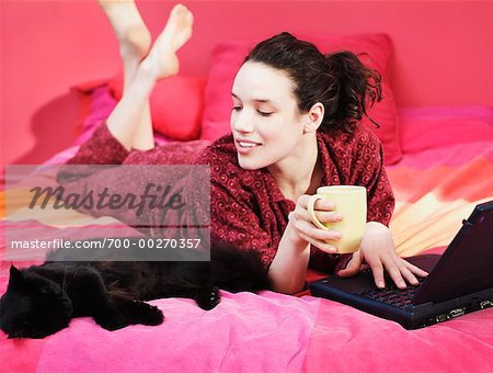 Woman Using Laptop on Bed