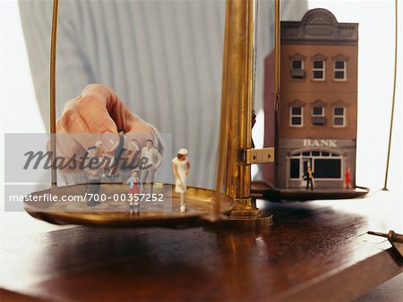 Figures of People and Model of Bank, Being Placed on Scale