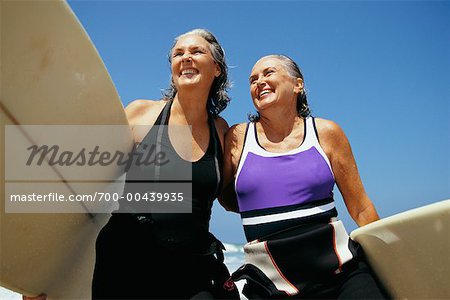Two Women Carrying Surfboards