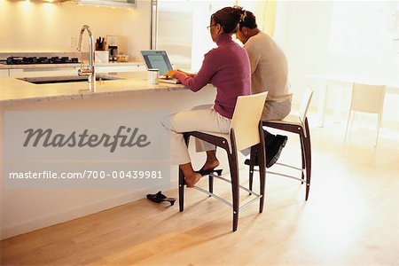 Couple Doing Computer Banking in Kitchen