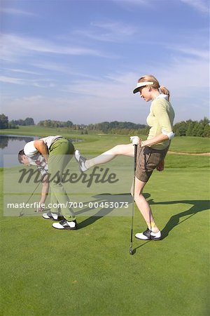 Woman Kicking Man at Golf Course
