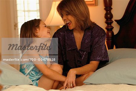 Mother and Daughter Sitting on Bed