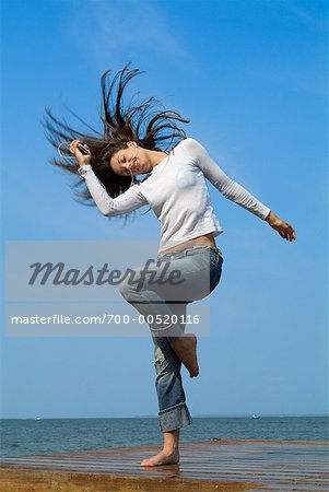 Woman Standing on Dock, Using MP3 Player