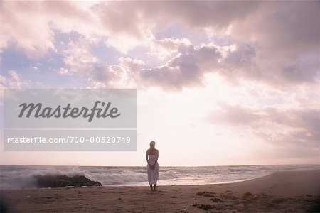 Woman Standing on Beach at Dusk