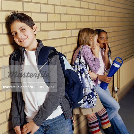 Boy Leaning on Wall and Girls Whispering