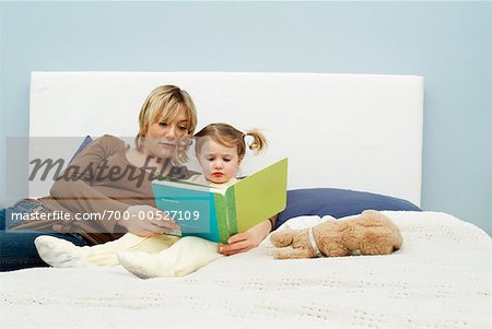 Mother Reading to Daughter on Bed