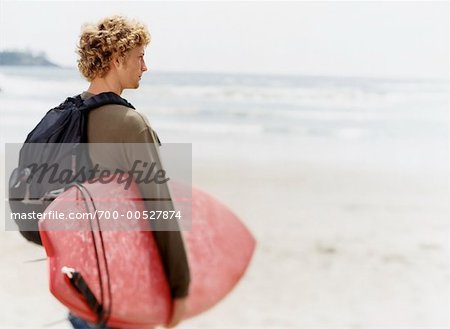 Man With Surfboard Looking At the Ocean