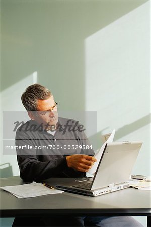 Businessman Reading Papers In Office