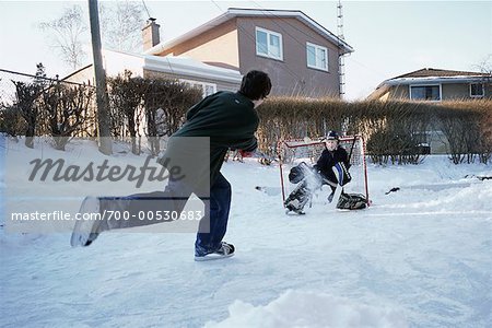 Teenagers Playing Hockey In Backyard Stock Photo Masterfile