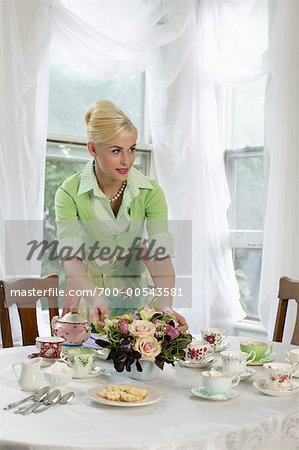Woman Setting Table with Vintage Teacups