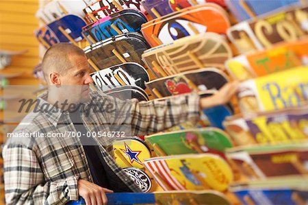 Man Looking at Skateboards in Store