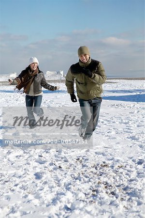Man and Woman Running through Snow