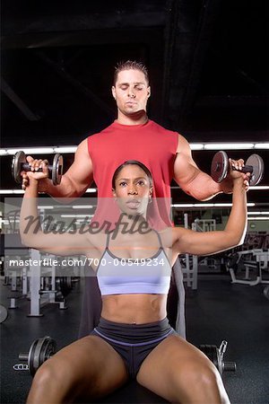Woman Lifting Weights with Personal Trainer
