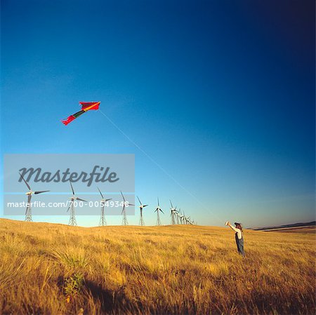Child Flying Kite by Wind Turbines