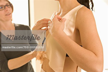 Seamstress Helping Woman Try On Wedding Dress