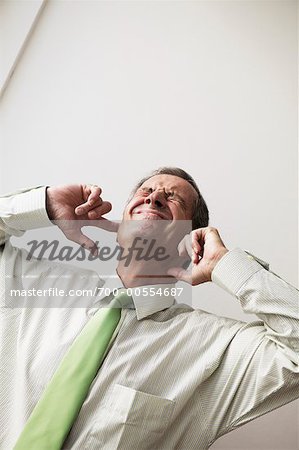 Businessman Plugging Ears
